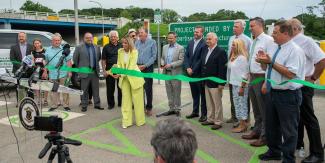 state officials cutting a ribbon to open new ev chargers